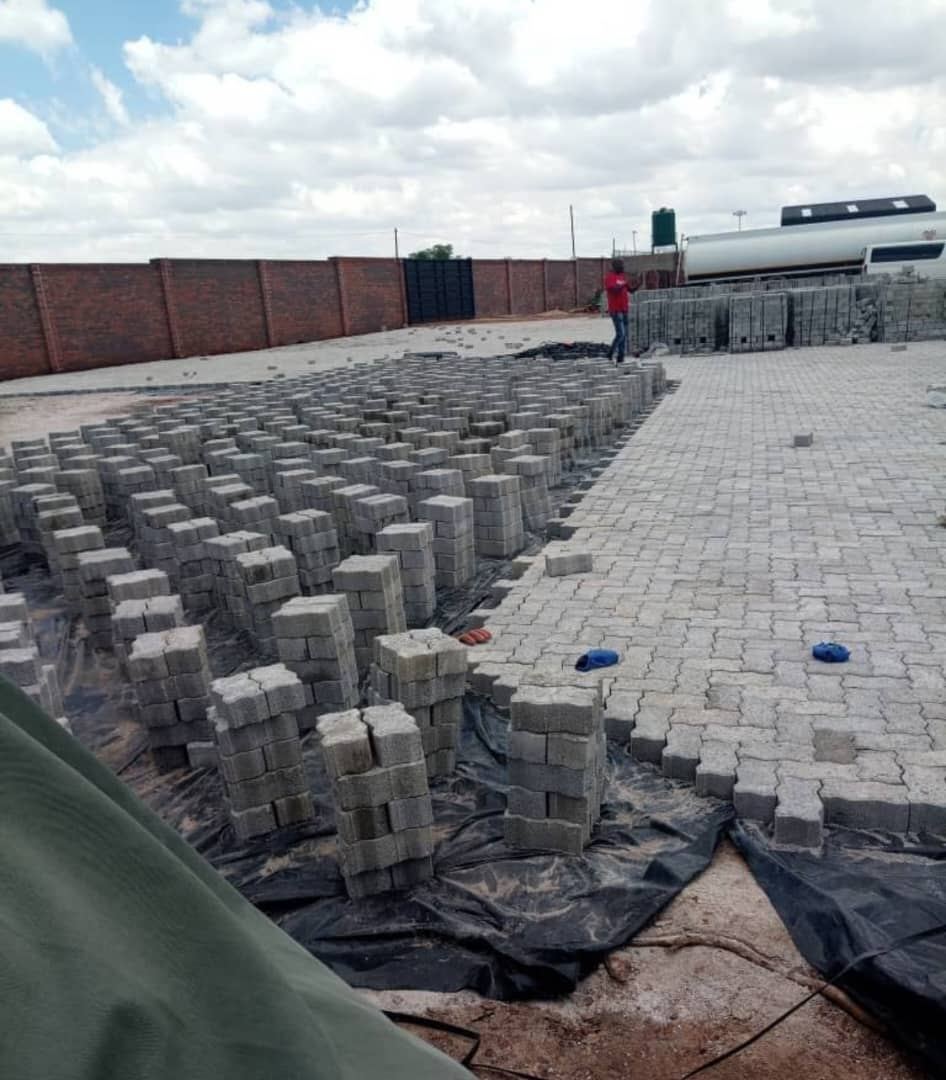 Paving bricks being laid across a large yard